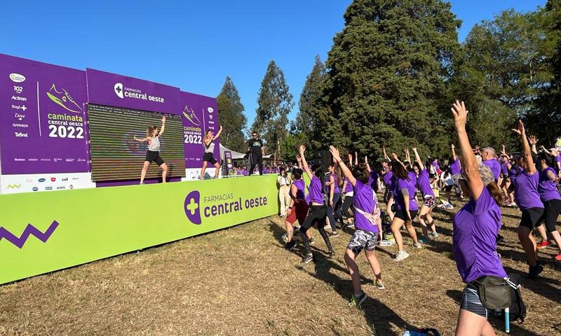 Una mujer hace gimnasia en un escenario mientras otras personas la siguen