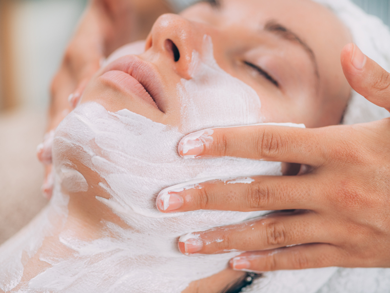 Una mujer recibiendo un masaje facial