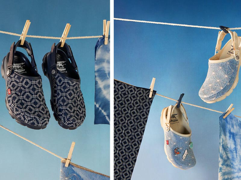 Levi’s x Crocs zuecos colgando de una soga con el cielo y ropa batik de fondo