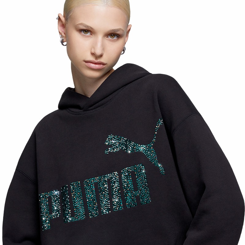 Modelo mujer rubia vistiendo la hoodie de Puma intervenida por Swarovski Creators Lab