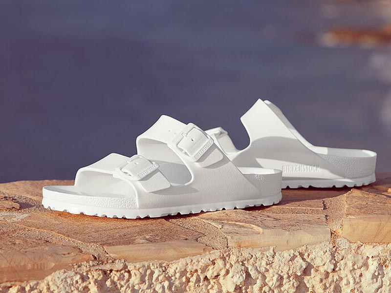 Sandalias blancas Birkenstock frente al mar