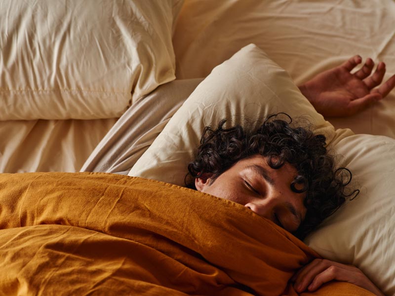 Un hombre durmiendo plácidamente sobre un colchón Calm