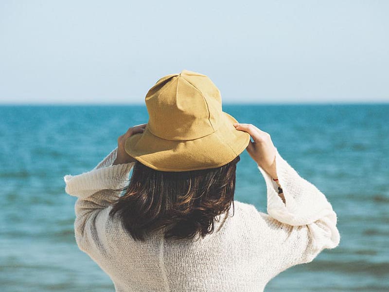 Mujer en la playa con sombrero